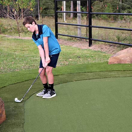 Boy playing golf on SYNLawn Artificial Turf